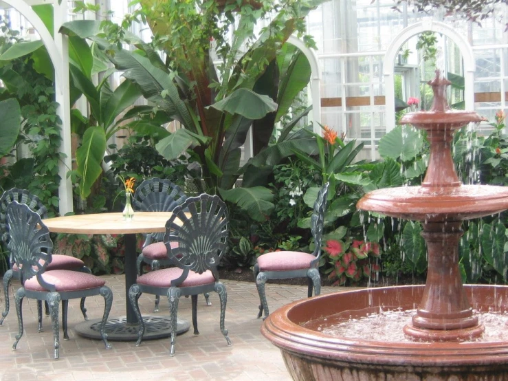 two circular tables with chairs and one table topped with a water fountain