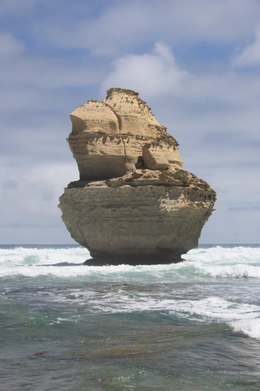 a rock formation in the ocean near the beach