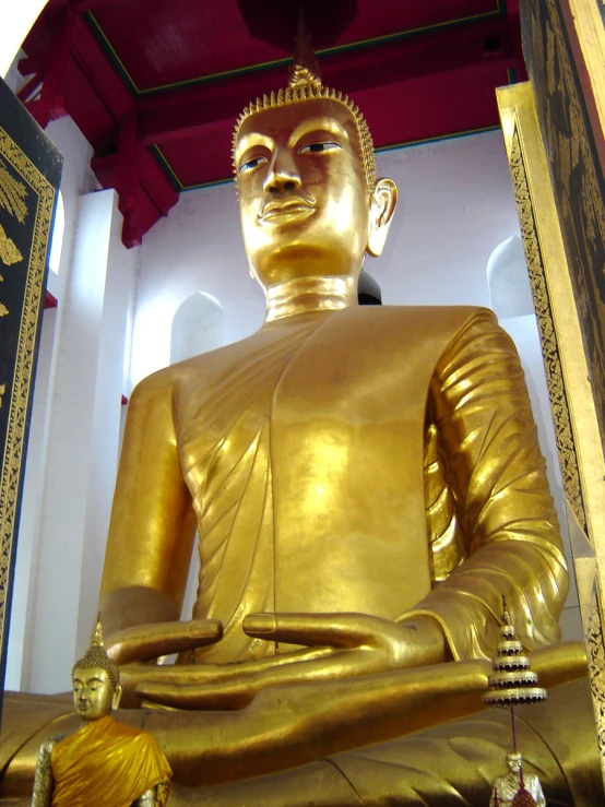 the gold buddha statue is in a room