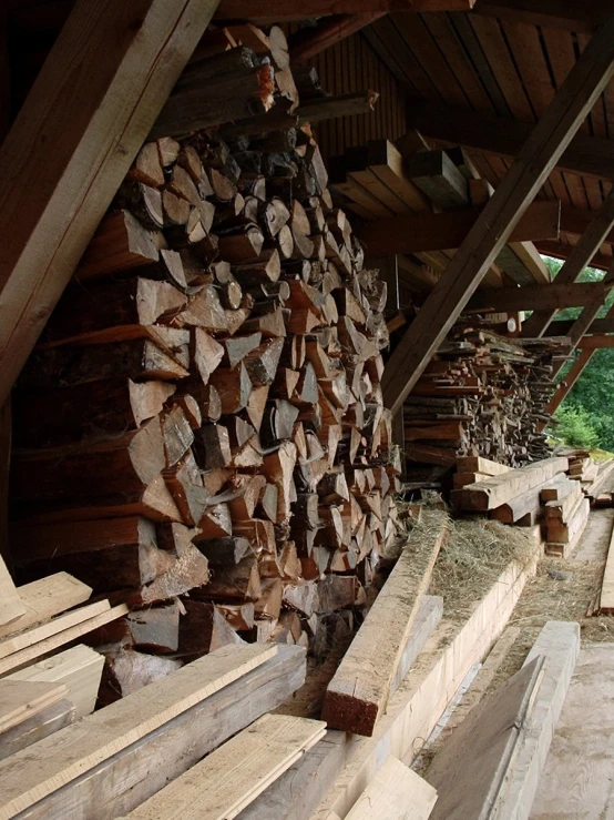 a pile of logs near a window in a shed