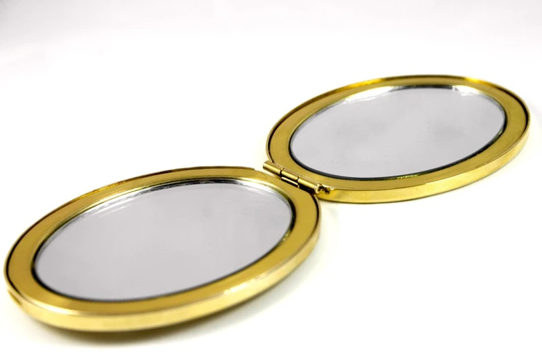two mirrors sitting on top of a white surface