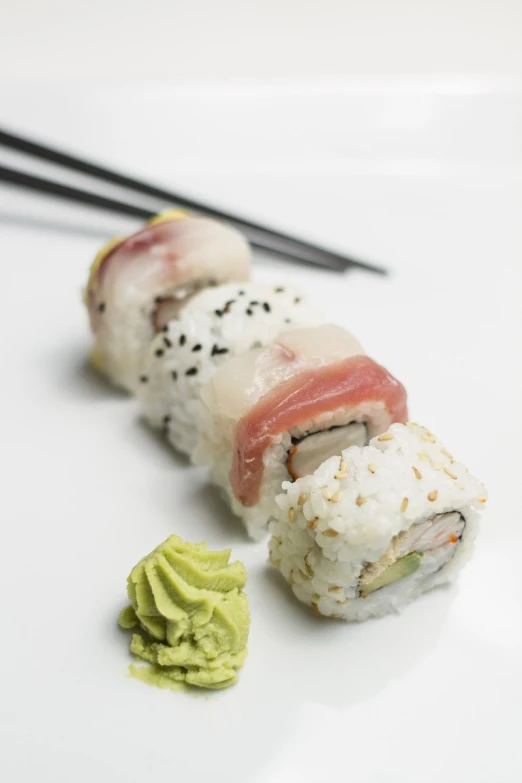 a piece of sushi and some guacamole on a plate