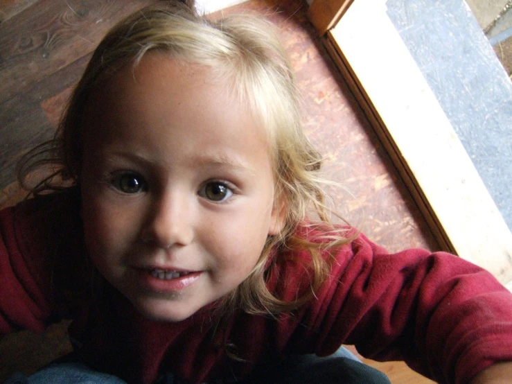 a little girl sits on the floor and smiles