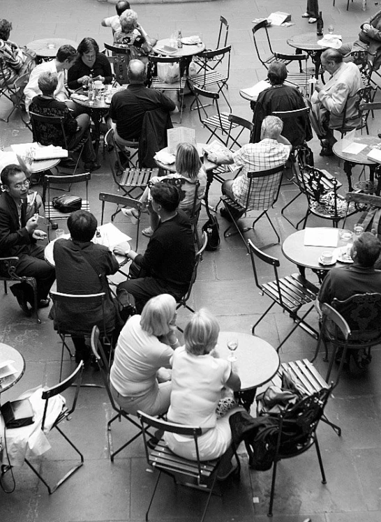 a large group of people sitting at tables eating food