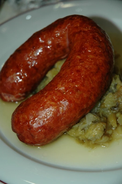 some sausages are cooked in a white bowl