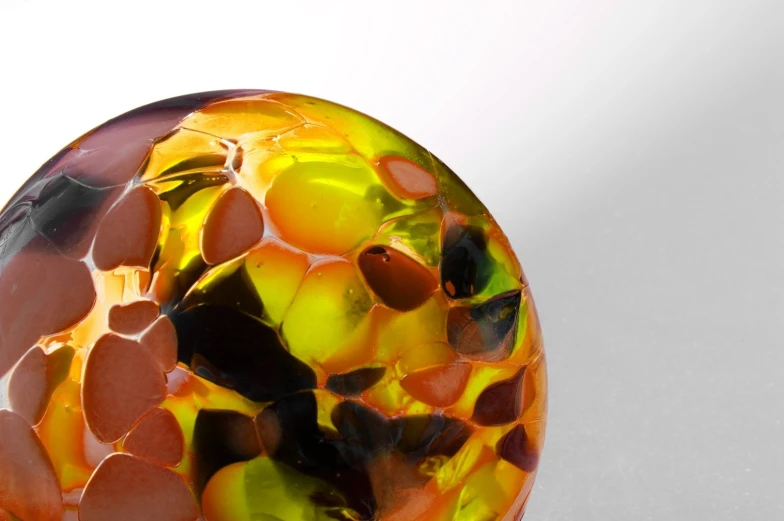 a very colorful glass ball sitting on top of a table