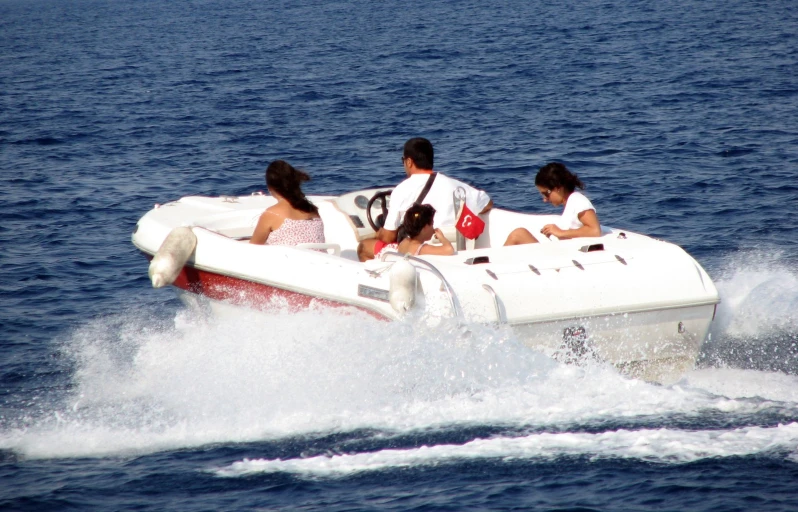 four people are riding a boat with no seats