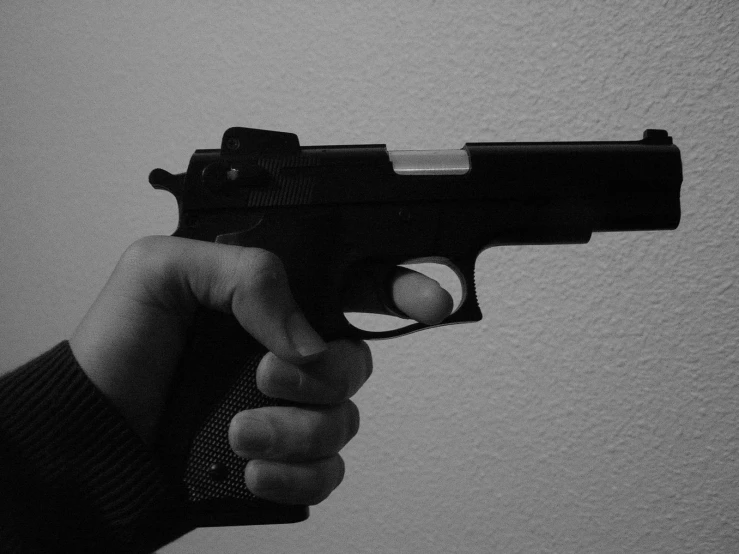 a person holding up a gun in black and white