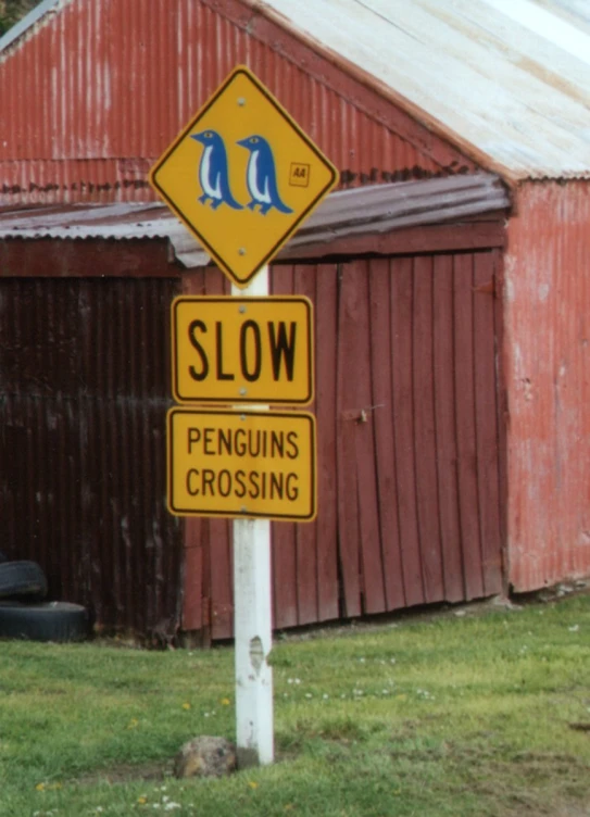 there are two signs in front of a red barn