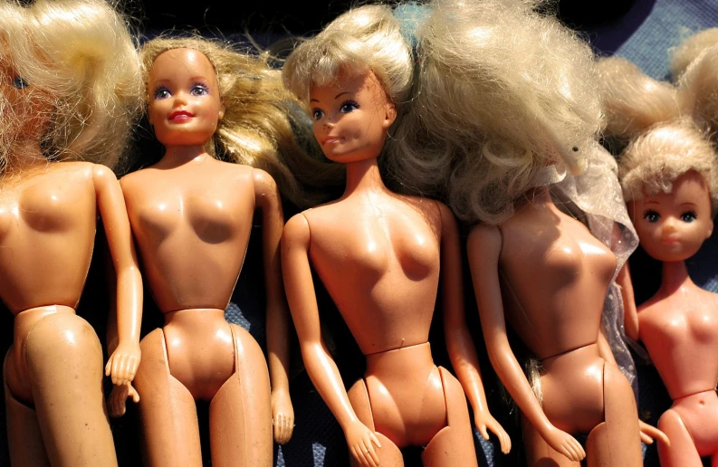 lots of blonde dolls lined up on a display