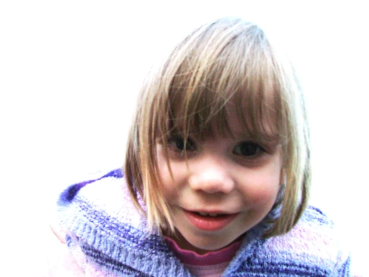 a young child wearing a blue coat standing in front of a wall