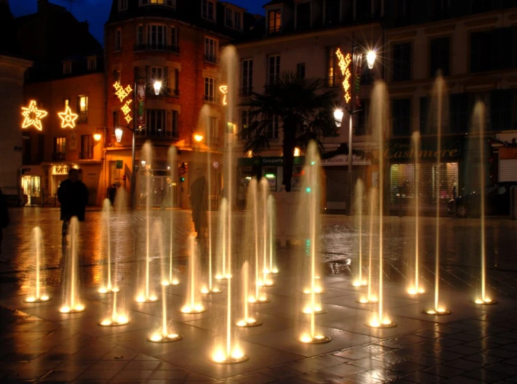 a bunch of fountains sitting outside of a large building