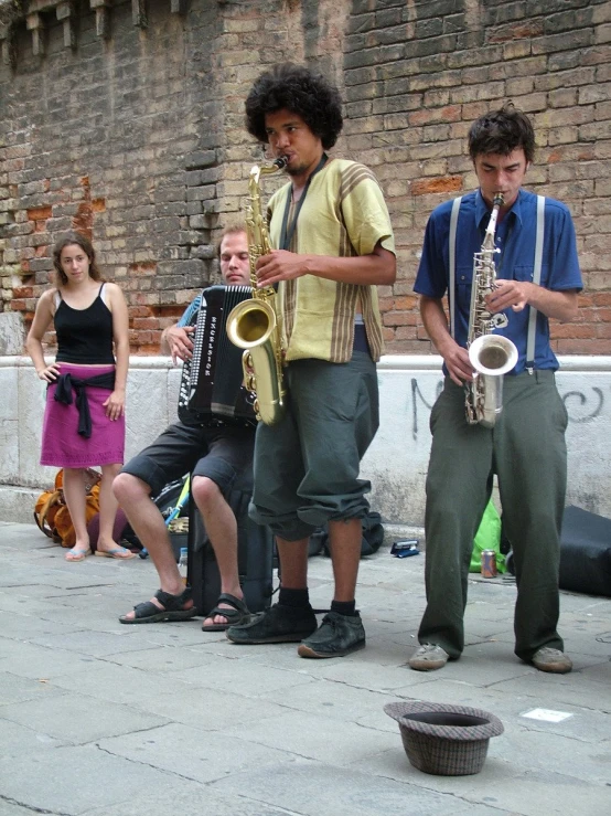 a group of young men standing around and playing musical instruments