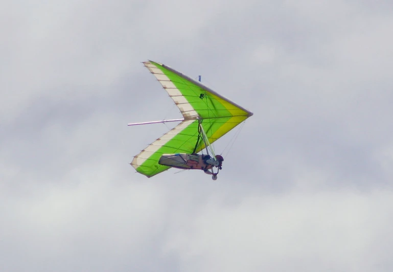 a person riding a kite against a cloudy sky