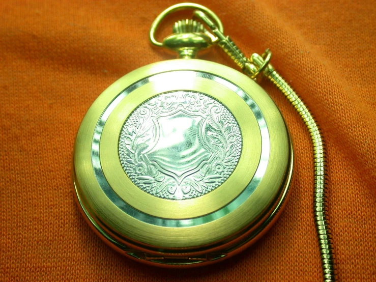 the pocket watch has a silver medallion on it