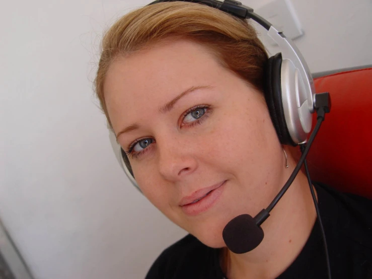 a woman is wearing headphones while listening to a tv