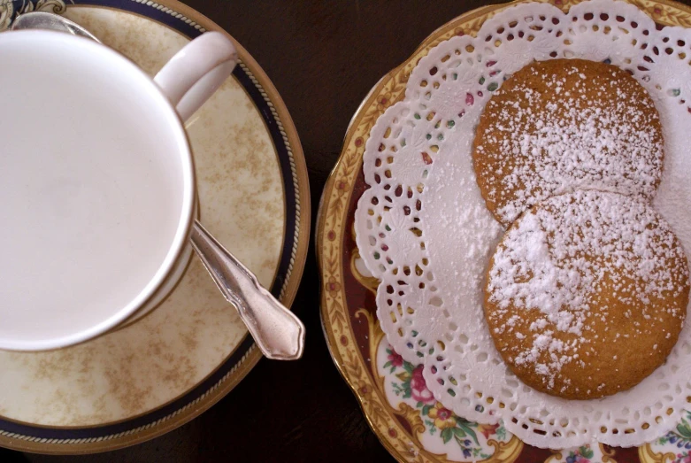 two plates with cakes on them and two bowls with a mug