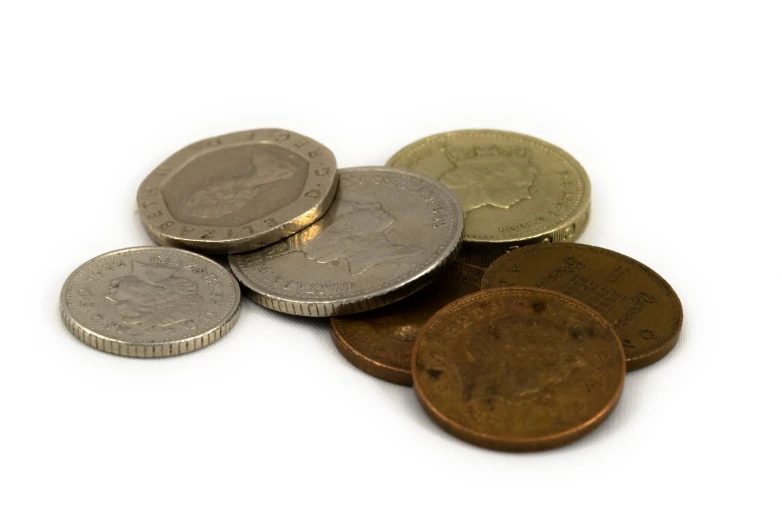 an assortment of british coins on a white surface