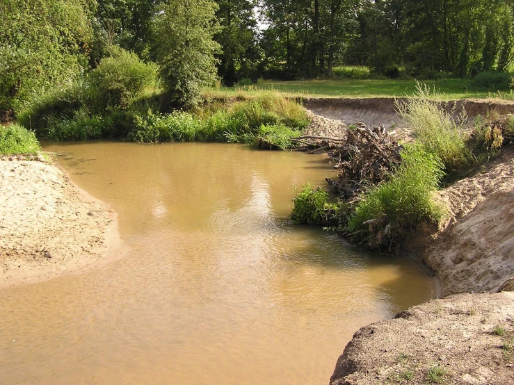 the stream is next to a large dirt hill