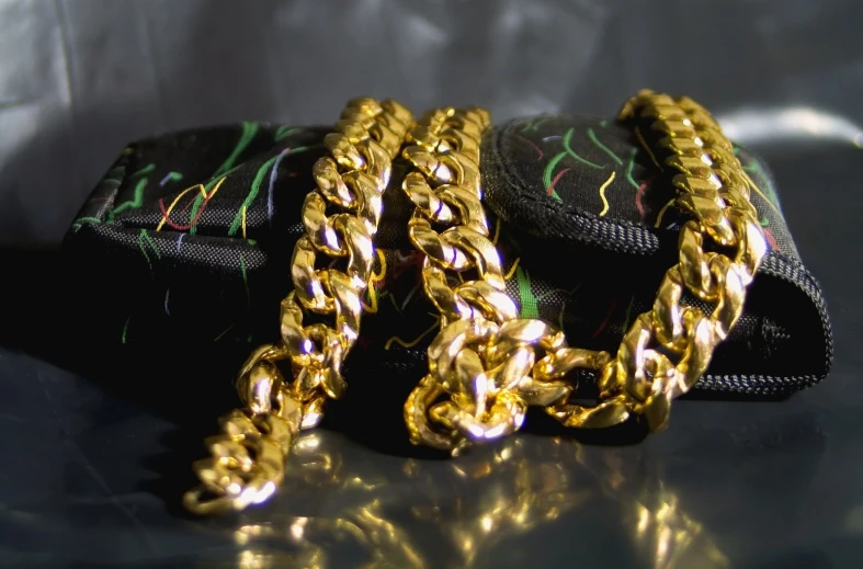 this is two gold chains sitting on a wallet