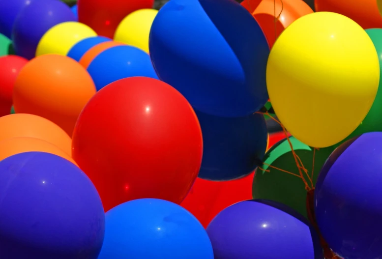 many colorful balloons fill the air in an image