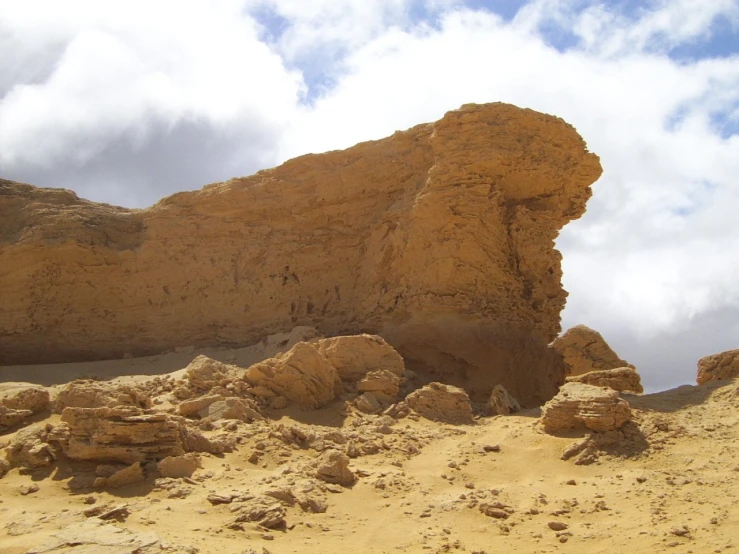 a large rock formation in a sandy area