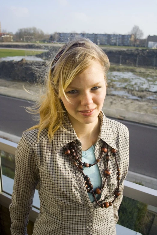 a  with blond hair wearing a necklace