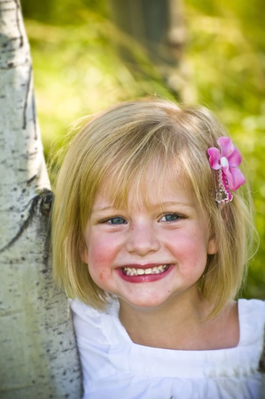 the  is posing near a tree