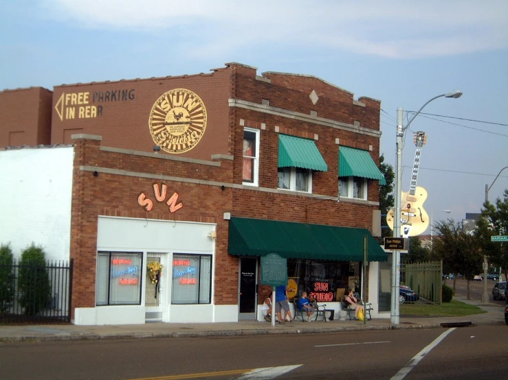 the outside of an older brick building with green awnings