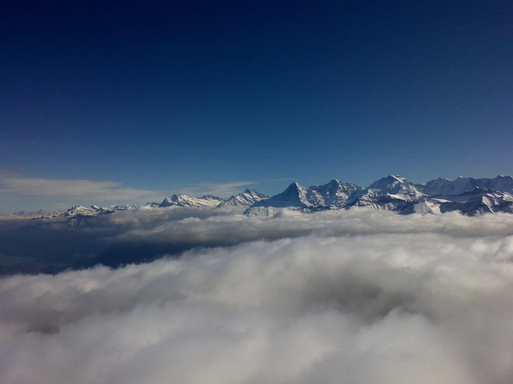 the view out an airplane window of some mountains covered in snow