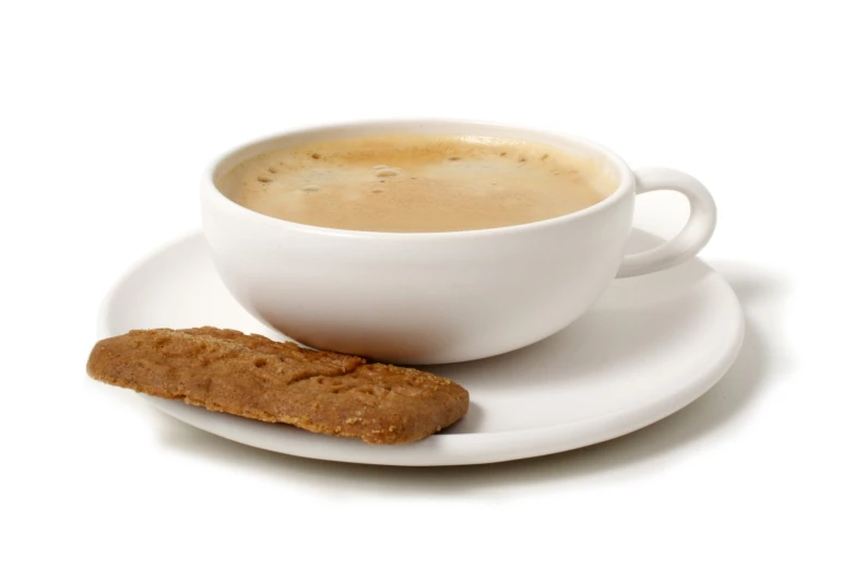 a white cup and saucer on a saucer next to an uncooked sandwich