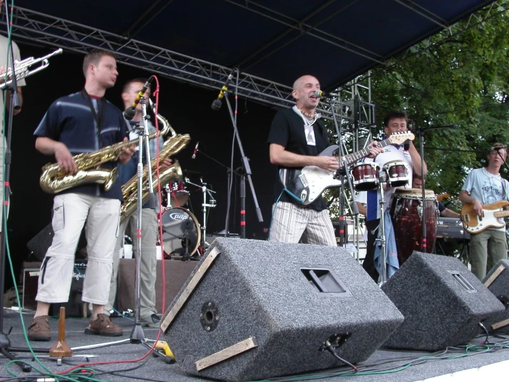 two men are standing on stage with guitars and singing