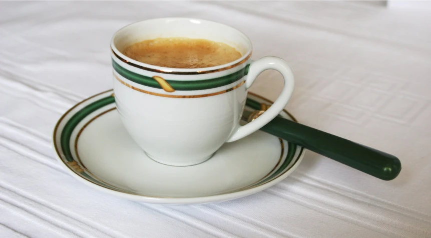 a stack of three white coffee cups filled with liquid