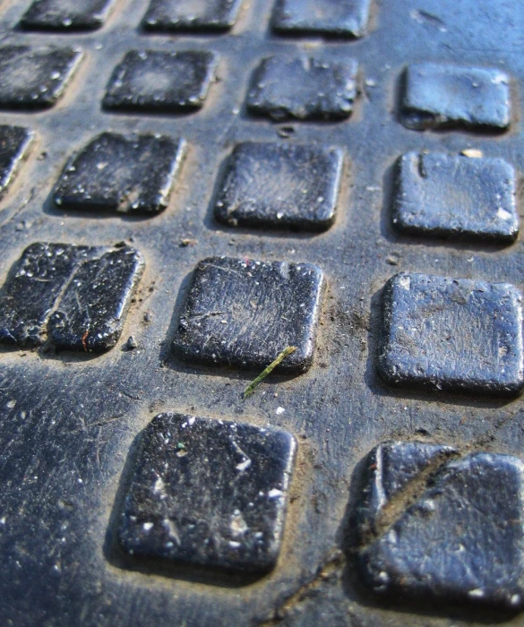 a close up s of a surface covered in black, square tiles