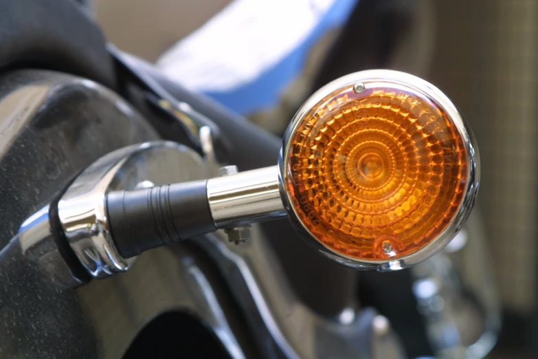 a close up of a motorcycle's light with it's tire visible