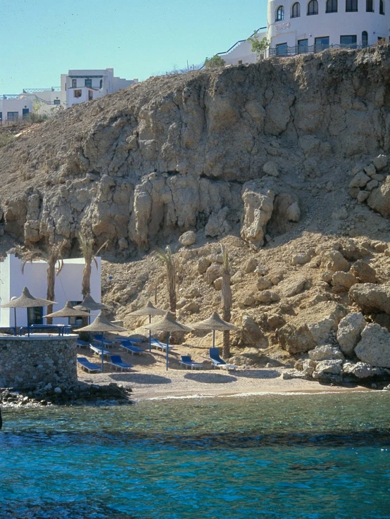 a view of beach chairs and umbrellas near the rocks