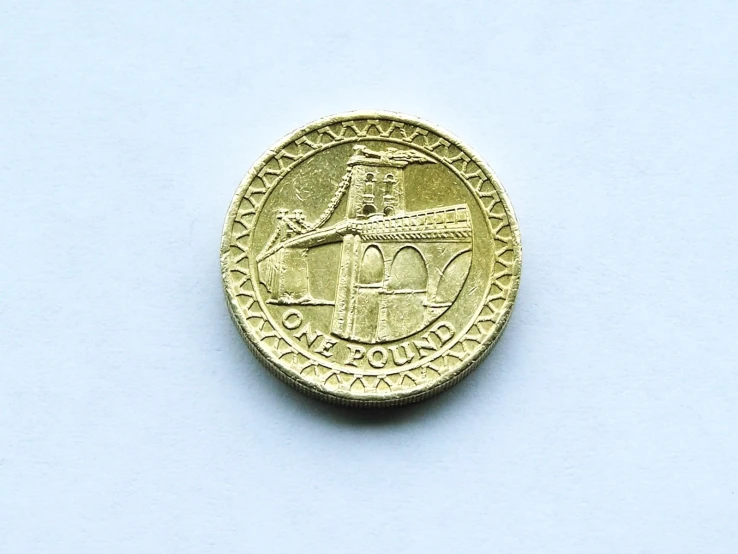 a gold coin is seen on the white surface