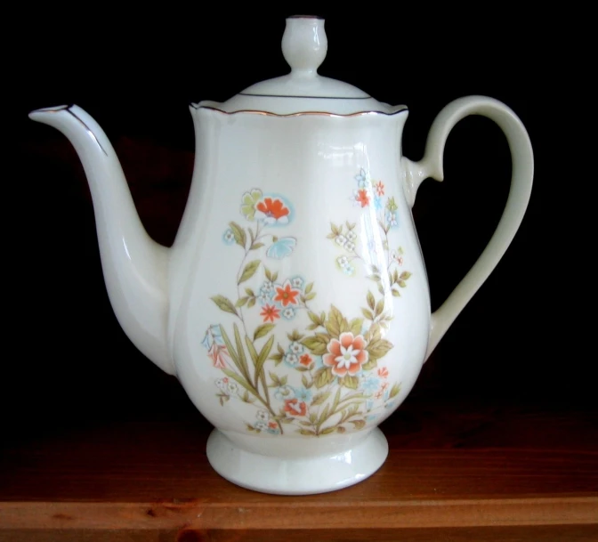 the flowered tea pot is decorated with an ornate flower