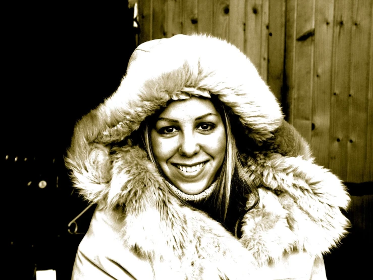 a woman with long hair wearing a winter coat and a hood