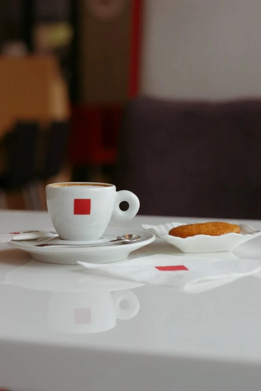 an empty coffee cup with a spoon on a plate