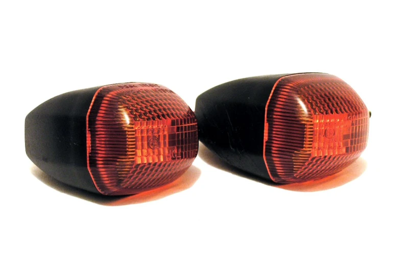 two black motorcycle turn signals with red light