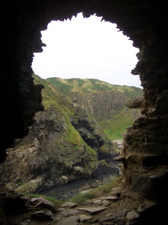 a rocky mountain with an arched window in it