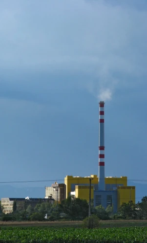 a factory with smoke coming from a chimney