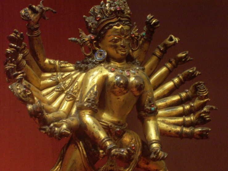 a gold statue with many arms and legs