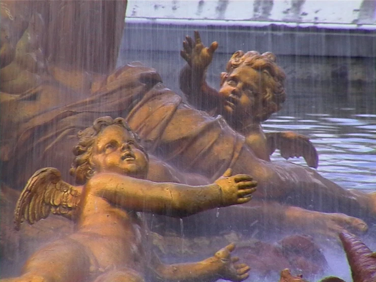 a statue of a man with his feet crossed and hands raised out in the water with another statue behind him