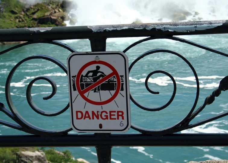 a sign is posted on a gate over the water