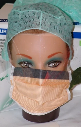 a face mannequin's head in front of a green surgical mask