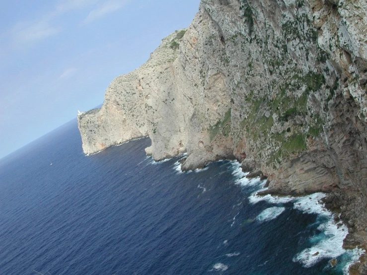 a large, rocky rock face with the ocean below