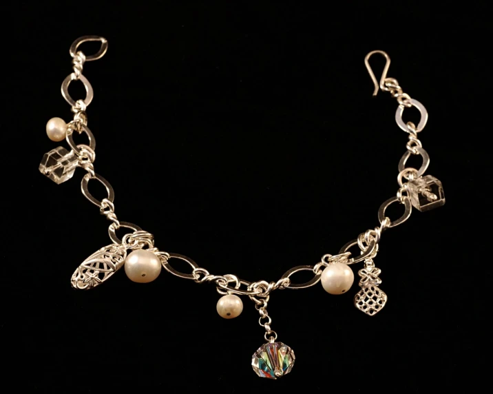 a necklace with charms and pearls on it