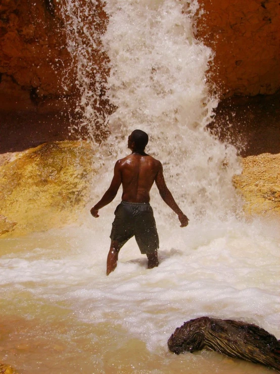 a person in the water near a waterfall